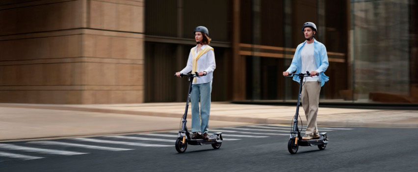 Zwei Personen fahren Navee GT5 Max E-Scooter nebeneinander in der Stadt – ideal für den täglichen Arbeitsweg