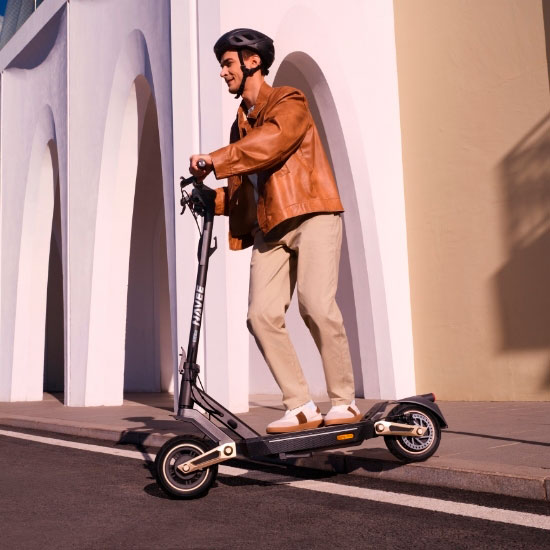 Mann in Lederjacke fährt leistungsstarken Navee ST E-Scooter mit Doppelfederung in sonniger Umgebung