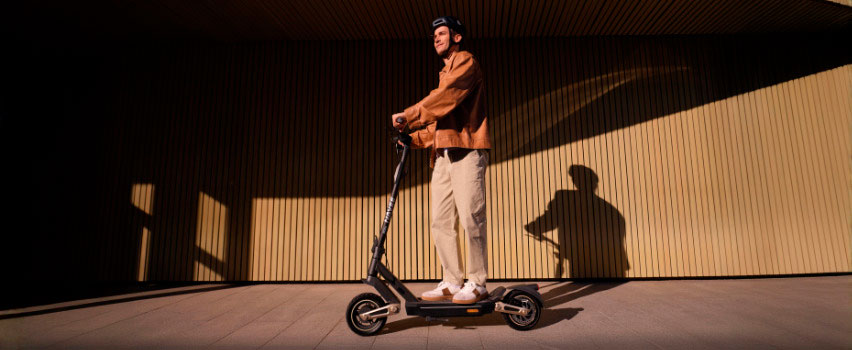 Mann fährt Navee ST3 Pro E-Scooter mit robusten Reifen und Premium-Design im Abendlicht