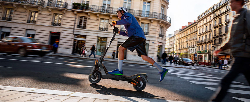 Mann fährt Navee ST3 Pro E-Scooter mit robusten Reifen und Premium-Design im Abendlicht