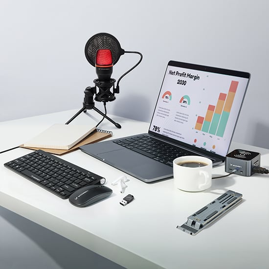 Wozinsky Computerzubehör mit Tastatur, Maus, Mikrofon, Laptop-Ständer und Kaffeetasse auf hellem Schreibtisch